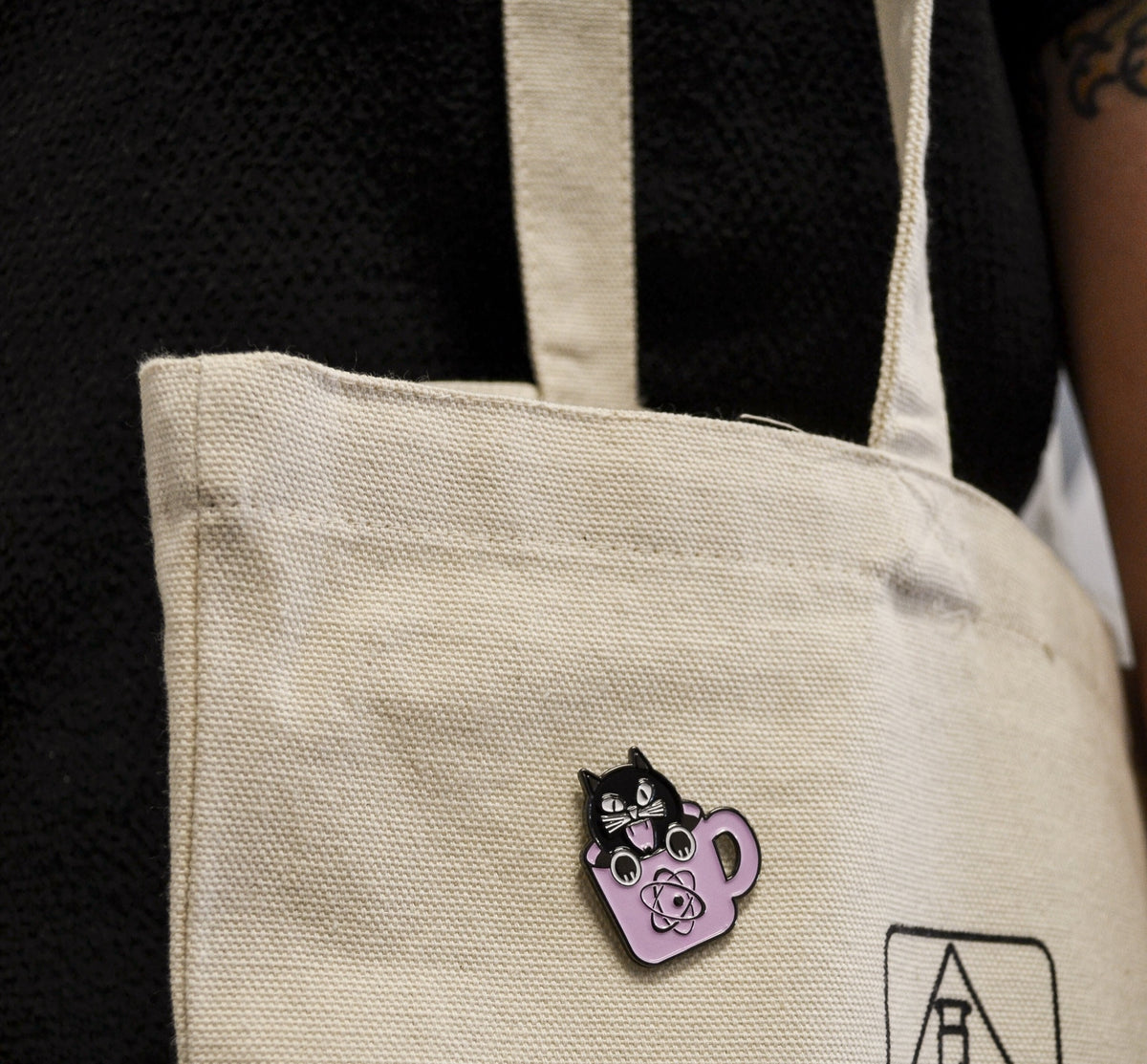 Witch City Black Cat enamel pin on a canvas tote bag