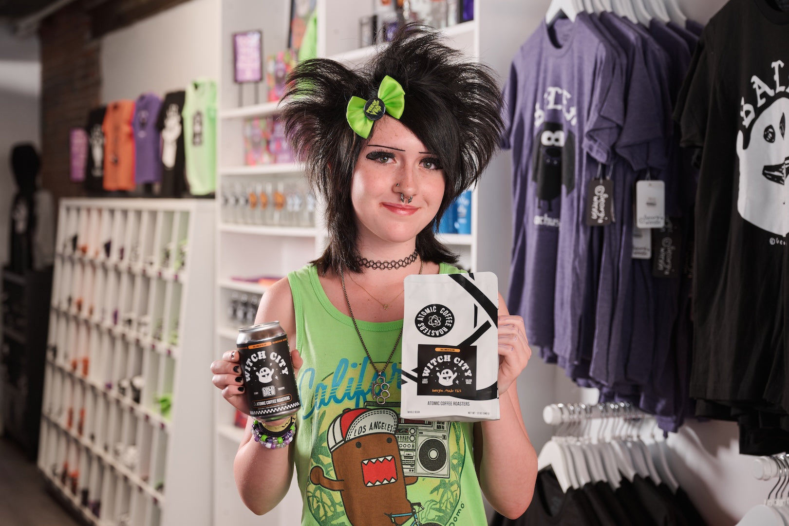 Georgia Wrenn in her Salem shop holding the 2026 Witch City bag and cold brew can